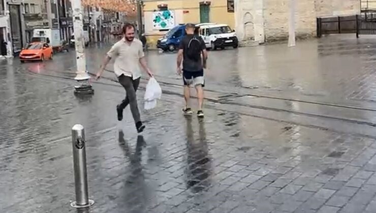 Taksim’de yağmur etkili oldu: Bir vatandaş yağmurdan kartonla korundu